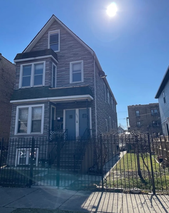 view of front of home with a fenced front yard and a gate