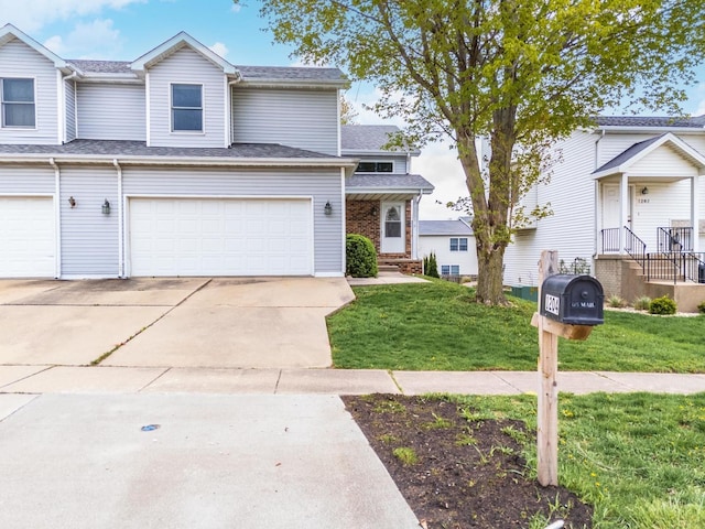 view of property featuring a garage, concrete driveway, and a front lawn
