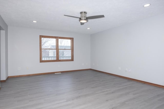 empty room with baseboards, a ceiling fan, and wood finished floors
