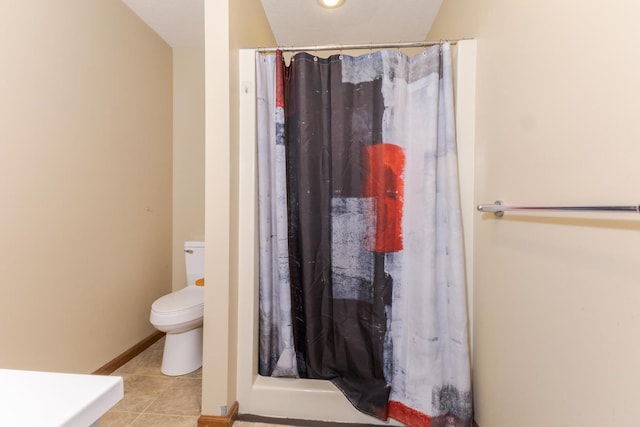 full bathroom with baseboards, a shower with shower curtain, tile patterned floors, and toilet