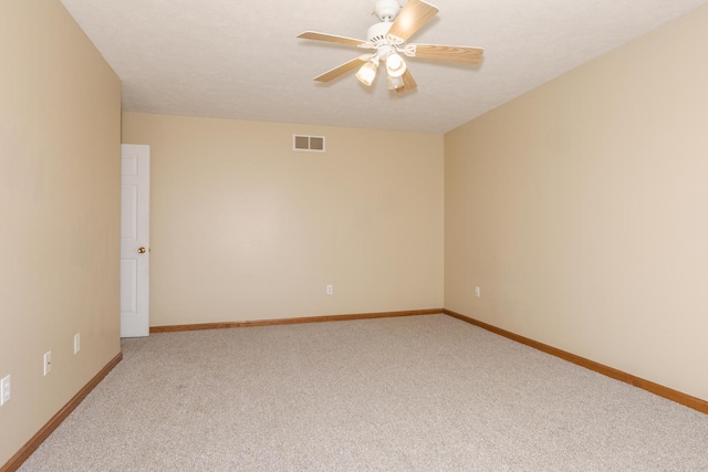empty room featuring baseboards, a ceiling fan, light colored carpet, and visible vents