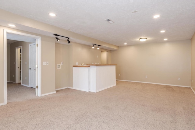 empty room with bar area, light carpet, and recessed lighting