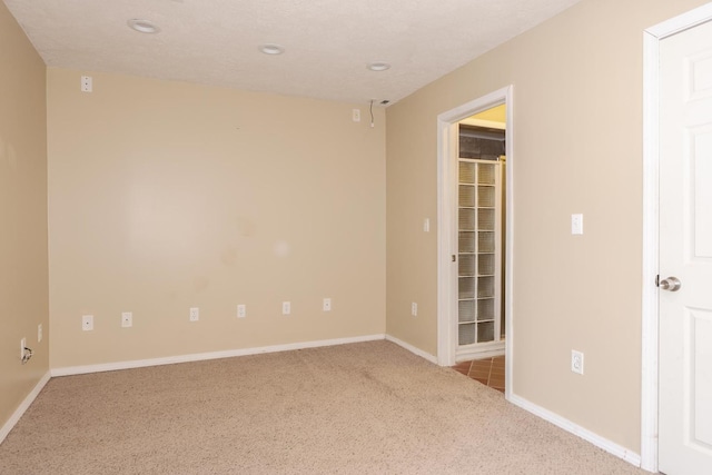carpeted spare room featuring recessed lighting and baseboards