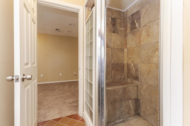 bathroom with tile patterned flooring and tiled shower