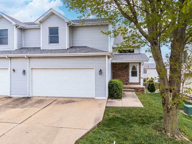 view of front of property with a garage, driveway, roof with shingles, and a front yard