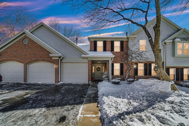 view of front of property with a garage, brick siding, and aphalt driveway