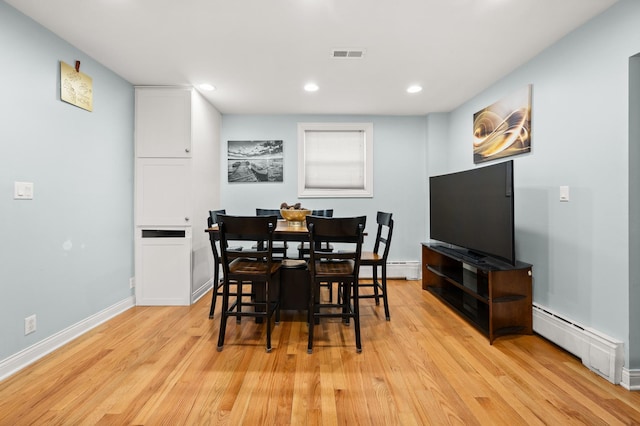 dining area with baseboard heating and light wood-type flooring