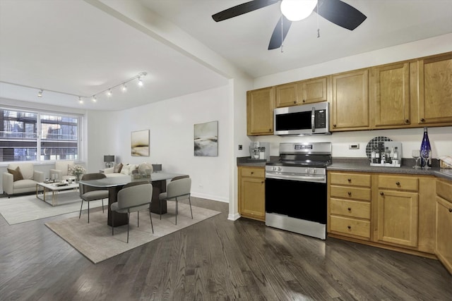 kitchen with brown cabinetry, dark countertops, dark wood-style floors, open floor plan, and stainless steel appliances