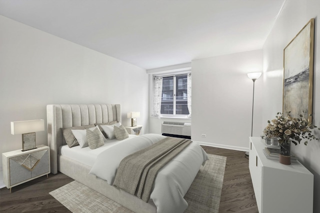 bedroom with dark wood-style floors, baseboards, and a wall mounted AC