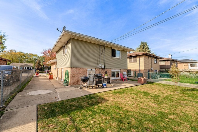 rear view of property with a yard and a patio area