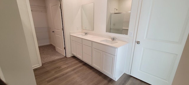 bathroom with a shower with door, wood-type flooring, and vanity