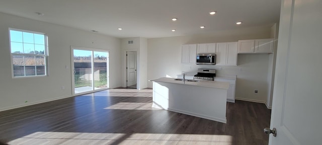 kitchen featuring white cabinetry, appliances with stainless steel finishes, a kitchen island with sink, and dark wood-type flooring