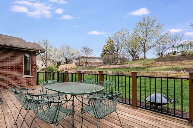 wooden deck featuring a lawn and outdoor dining area