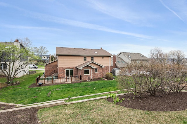 rear view of property featuring a lawn, a patio area, and brick siding