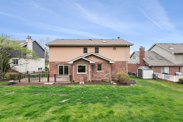 back of house featuring brick siding, a shed, an outbuilding, and a lawn