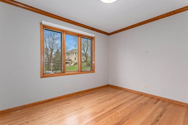 unfurnished room featuring light wood-type flooring, crown molding, and baseboards