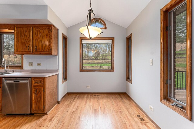 kitchen featuring visible vents, dishwasher, light wood-style flooring, and brown cabinetry