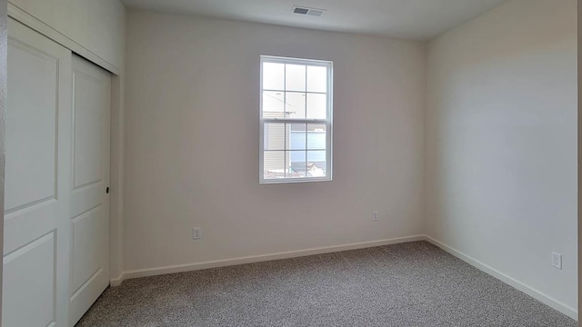 unfurnished bedroom featuring carpet flooring and a closet