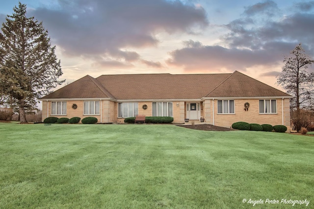 single story home featuring a lawn