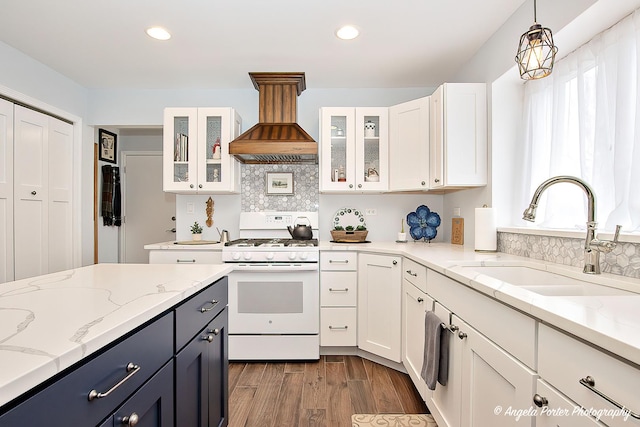 kitchen featuring sink, white cabinetry, light stone counters, white gas range, and custom exhaust hood