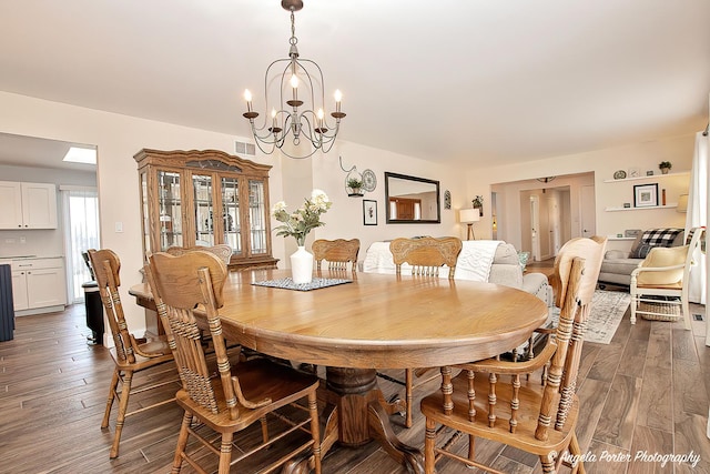 dining room featuring dark wood-type flooring and an inviting chandelier