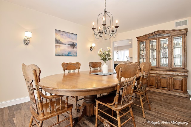 dining area featuring an inviting chandelier and dark wood-type flooring