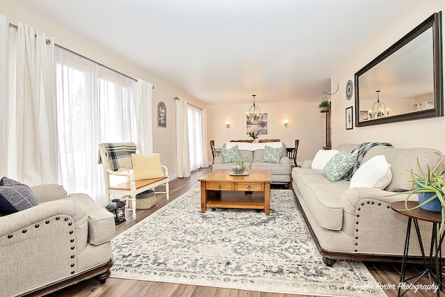 living room featuring wood-type flooring and an inviting chandelier