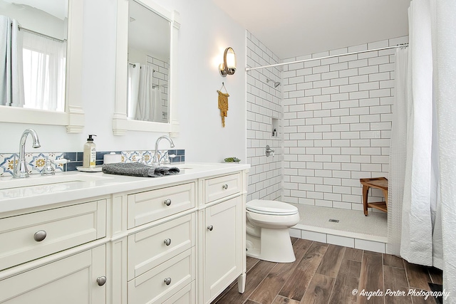 bathroom featuring vanity, hardwood / wood-style flooring, toilet, and walk in shower