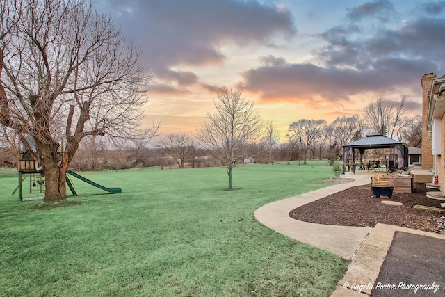 yard at dusk featuring a gazebo