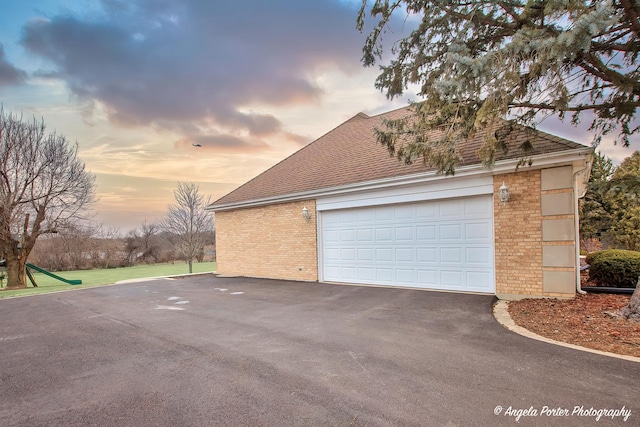 view of garage at dusk