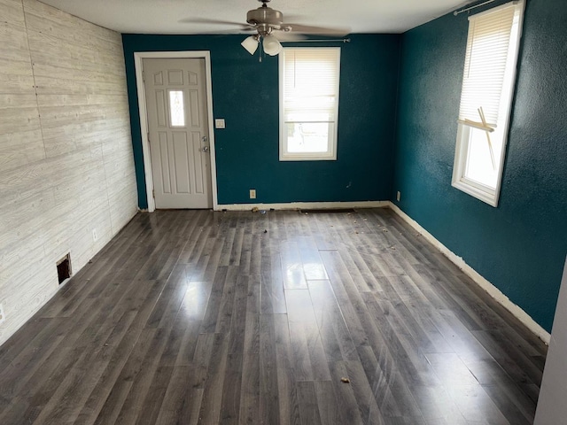 interior space with ceiling fan and dark hardwood / wood-style flooring