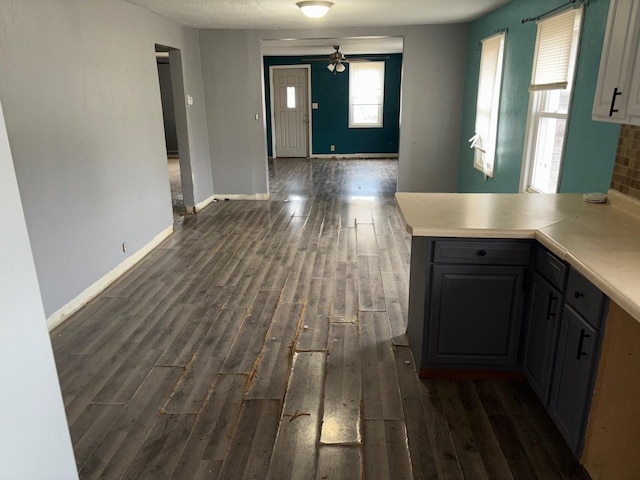 interior space with gray cabinets, kitchen peninsula, dark hardwood / wood-style flooring, and decorative backsplash