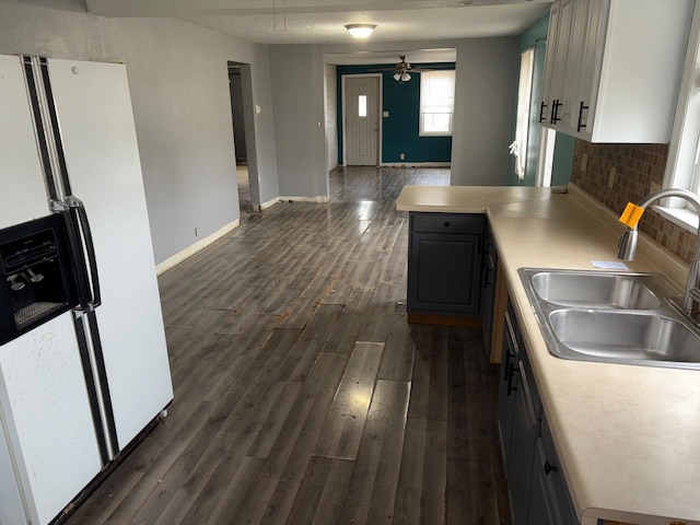 kitchen with sink, dark hardwood / wood-style floors, gray cabinets, white refrigerator with ice dispenser, and decorative backsplash