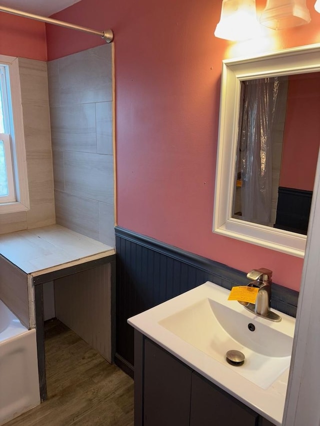 bathroom featuring wood-type flooring, a bathing tub, and vanity