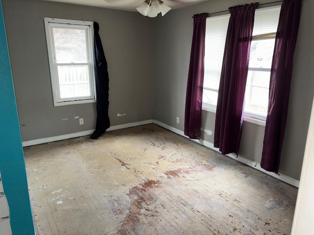 empty room featuring a wealth of natural light and ceiling fan