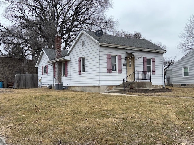 bungalow-style home with a front yard and central air condition unit