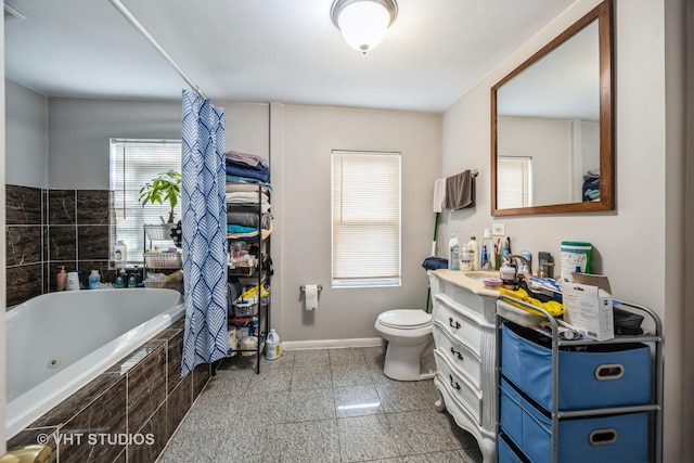 bathroom featuring a relaxing tiled tub, vanity, and toilet