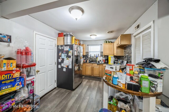 kitchen with hardwood / wood-style floors, backsplash, light brown cabinetry, and stainless steel fridge with ice dispenser