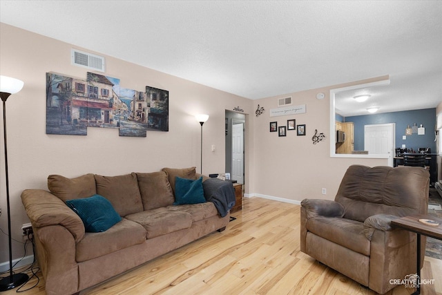 living room featuring wood-type flooring and a textured ceiling