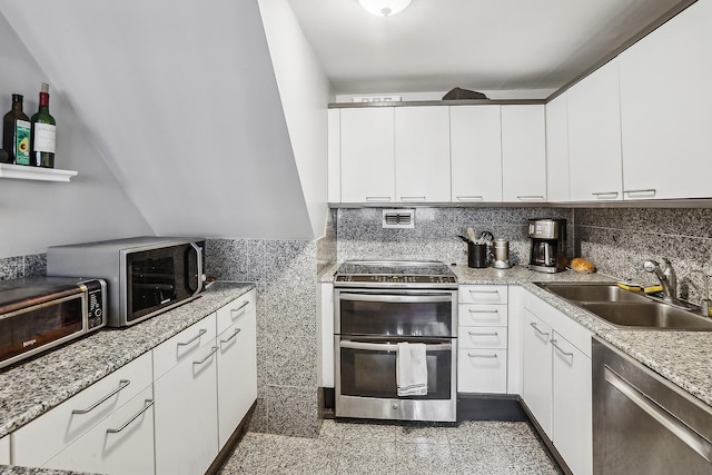 kitchen with white cabinetry, appliances with stainless steel finishes, sink, and backsplash