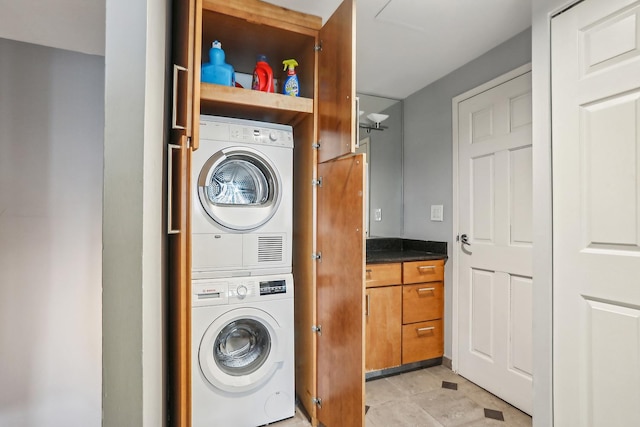 clothes washing area with stacked washer and clothes dryer