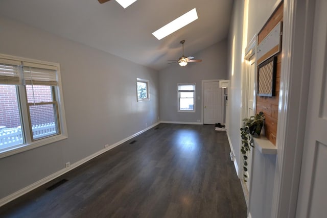 spare room with ceiling fan, dark hardwood / wood-style floors, a skylight, and high vaulted ceiling