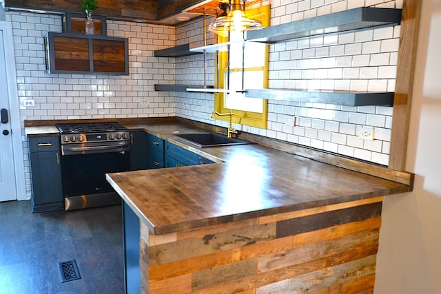 kitchen with sink, wooden counters, tasteful backsplash, stainless steel gas range oven, and blue cabinets