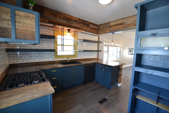 kitchen with pendant lighting, wood counters, dishwasher, sink, and blue cabinetry