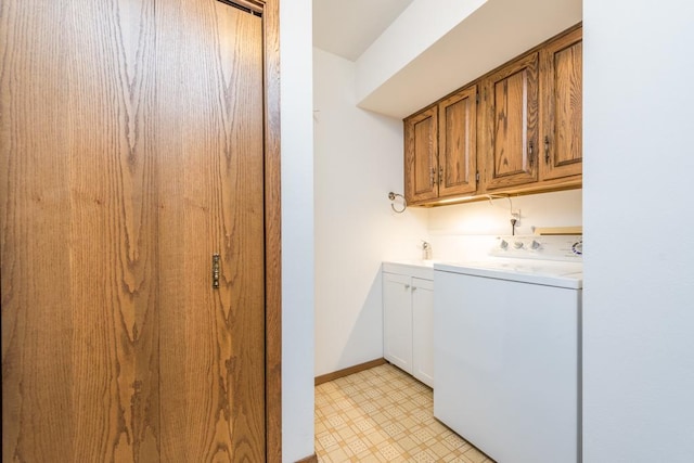 clothes washing area featuring washer / clothes dryer and cabinets