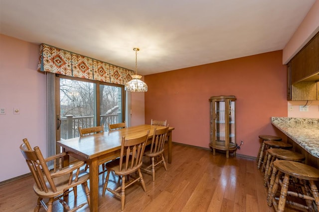 dining space featuring an inviting chandelier and light wood-type flooring