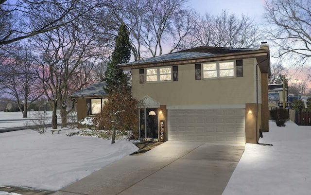 view of front of home with driveway, a garage, a chimney, and stucco siding