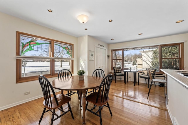 dining room with light wood-style floors, recessed lighting, and baseboards