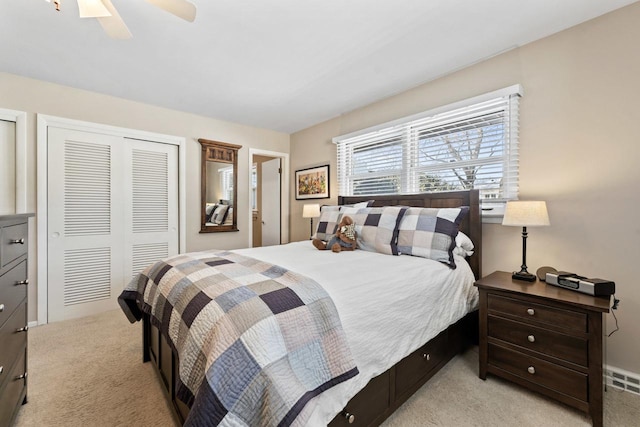 bedroom featuring light carpet, a closet, and a ceiling fan