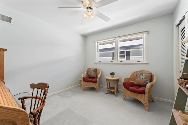 sitting room featuring baseboards, visible vents, ceiling fan, and carpet flooring